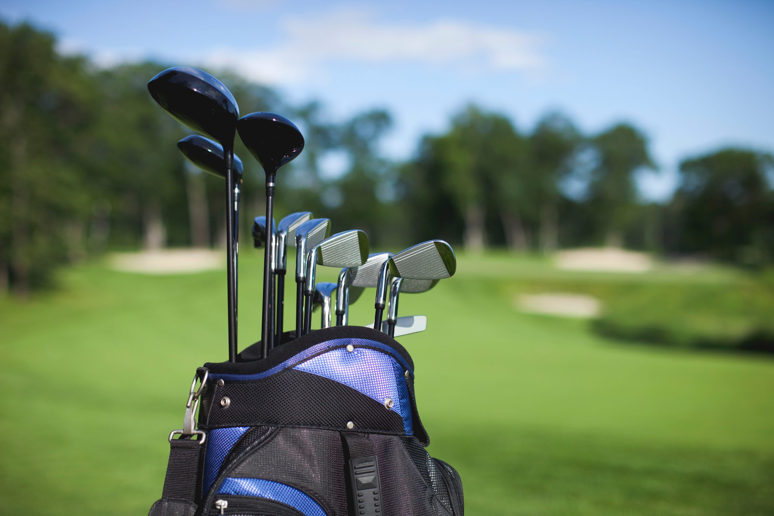 Golf bag and clubs against defocused course background